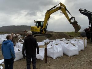 bags of gravel being filled by digger